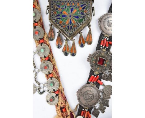 A Berber amulet box Morocco white metal and enamel, with a sliding cover and hung with six pendants, 14.5cm long, a Berber le