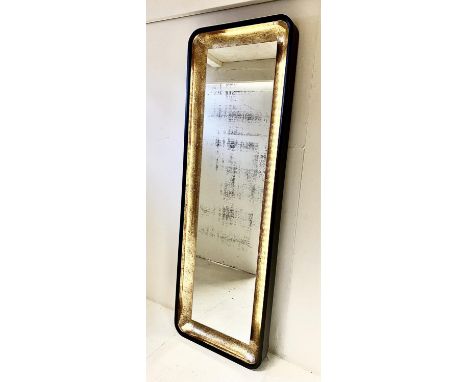 WALL MIRROR, black and gilt frame with light to detail, 180cm H x 60cm W. 