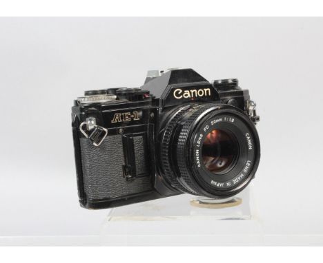 A Canon AE-1 SLR Camera, black, shutter working, meter responsive, self timer working, body G, some wear, with 50mm f/1.8 FD 