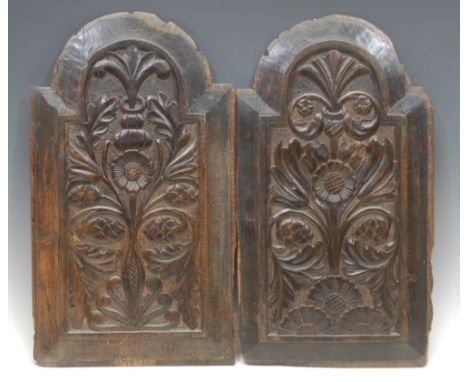 A pair of 18th century oak architectural fragments, the raised and fielded arched panels carved with flowers and foliage, 48c