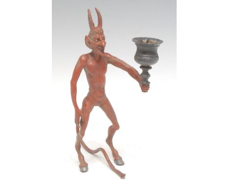 A 19th century cold-painted bronze figural candlestick, as a pagan devil with cloven hooves, he stands holding a campana scon