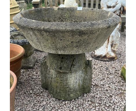 Large round stone planter on limestone base 