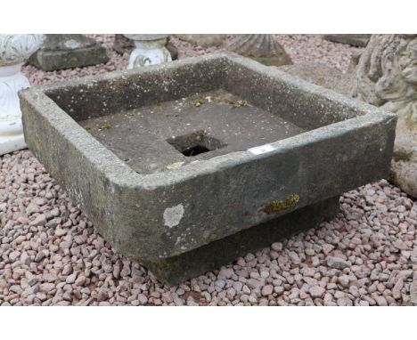 Old square stone trough on base