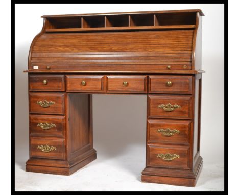 A contemporary mahogany 20th century twin pedestal roll top desk, the tambour front enclosing a pigeon hole over an arrangeme