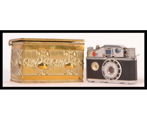 A vintage 20th Century novelty lighter modelled as a camera by KKW together with a late 19th Century brass match strike / ves