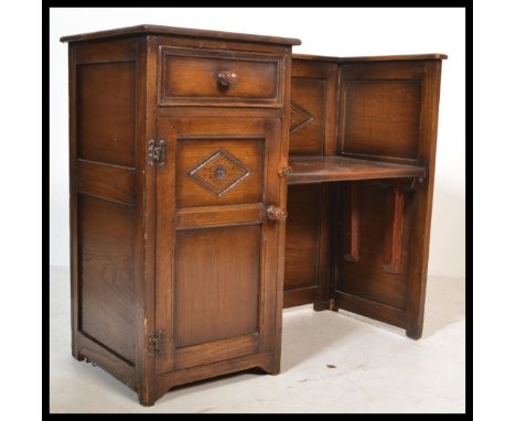 A good Ipswich oak hall settle bench having a flared top with drop centre seat over linen fold cupbard to the base. All raise