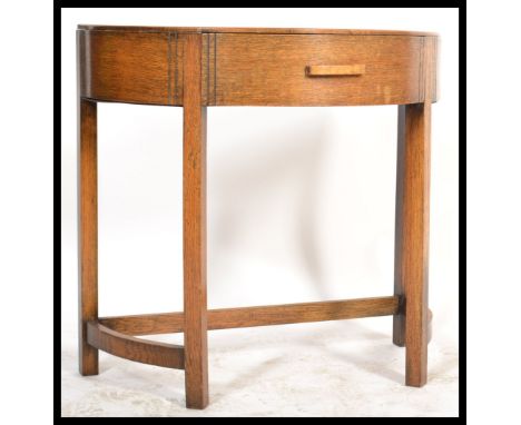 A 1930's Art Deco oak console hall table of demi - lune form by Fyne Lady. The table raised on squared legs with stretchers h