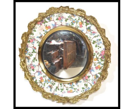 An early 20th century Burleigh Ware ceramic paint mirror having ormolu surround hand painted with birds and flowers.