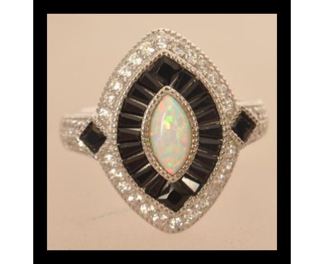 A sterling silver CZ and paneled sapphire dress ring with central lozenge shaped opal. Size P.5 weighs 7.9 grams.