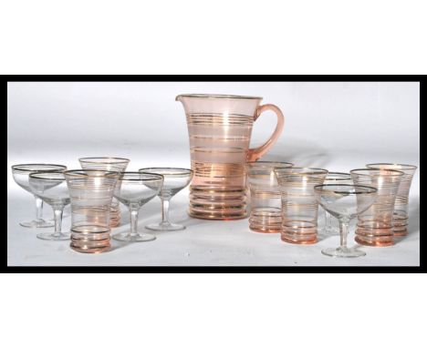 A retro mid century lemonade set in flash ruby glass with jug and glasses having banded design together with a set of champag