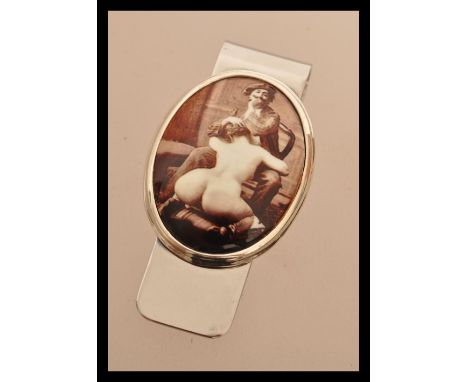 A sterling silver money clip having an erotic enamel panel scene. Weighs 20 grams.