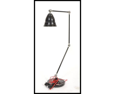 A large vintage retro floor standing anglepoise lamp having a black enamel finish with red enamel interior to the ribbed bell