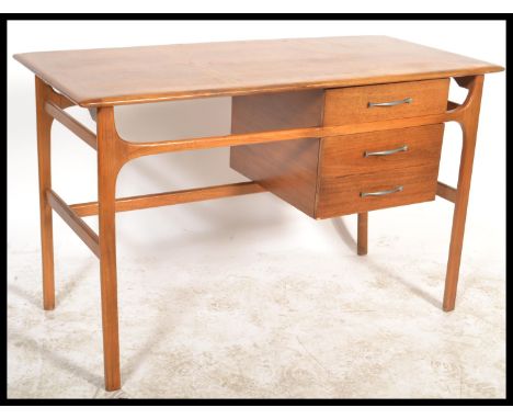 A vintage retro 20th century Danish Influence teak and beech wood writing desk raised on tapered legs and supports having a b