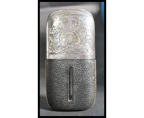 An early 20th century silver plated hunting interest leather and glass hip flask having scrolled decoration with plain armori