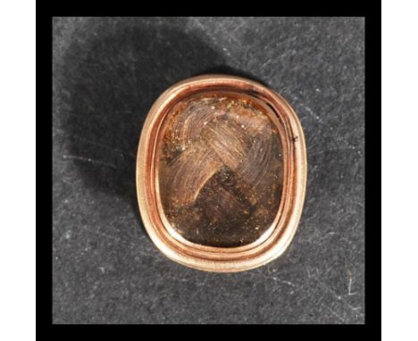 A 9ct gold mourning collar stud button with inset woven lock of hair. Weighs 2.5 grams.