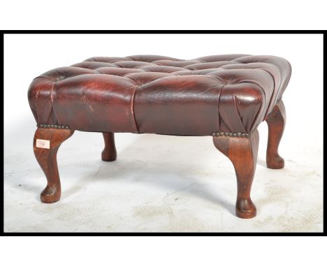 An antique style Chesterfield footstool having button backed oxblood leather top raised on cabriole legs with pad feet.&nbsp;