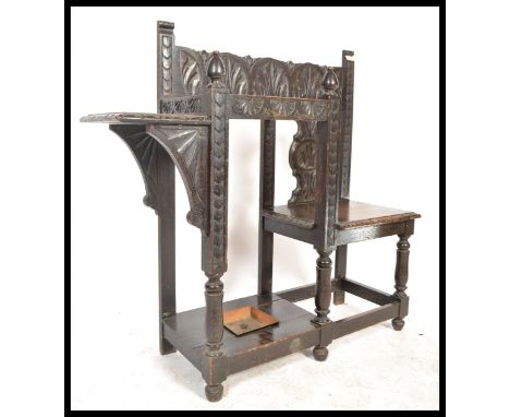 A 19th century Victorian carved oak Jacobean revival hall settle seat chair of unusual form having a central stick umbrella s