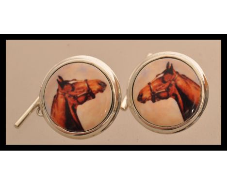 A pair of sterling silver cuff links having enamel panels depicting horses. Weighs 11 grams.