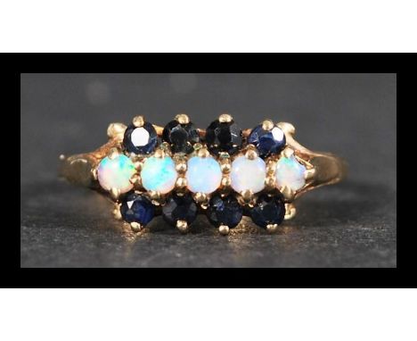 A hallmarked 9ct gold sapphire and opal ring being set with 5 opal cabochon and 8 blue sapphires. Hallmarked Birmingham. Weig