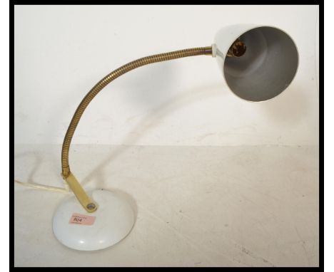 A vintage retro 20th century goose neck anglepoise lamp raised on a white circular base with brass gooseneck and conical pend