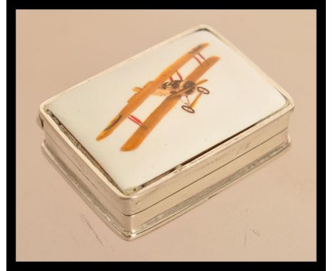 A sterling silver pill box having an enamel plaque of a bi plane to lid. Weighs 28 grams.