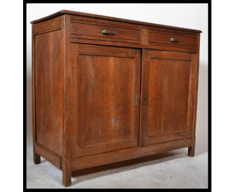 An early 20th Century rustic French Elm Buffet sideboard having two drawers over two panel doors and raised on stile legs&nbs