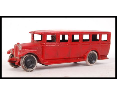A vintage early 20th Century Skoglund And Olsen Seto cast iron school bus in red with driver and white painted wheels. Mould 