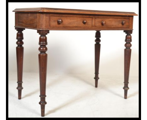 A Victorian mahogany writing table desk being raised on tapering legs with fitted frieze drawers having inset carved detailed