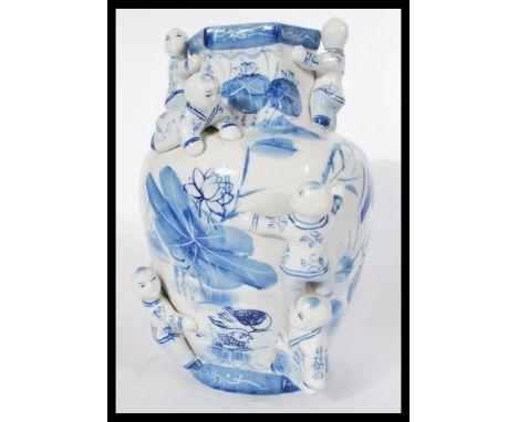 A Chinese large vase / jar having hand painted blue and white decoration depicting people with ceramic figures of children cl