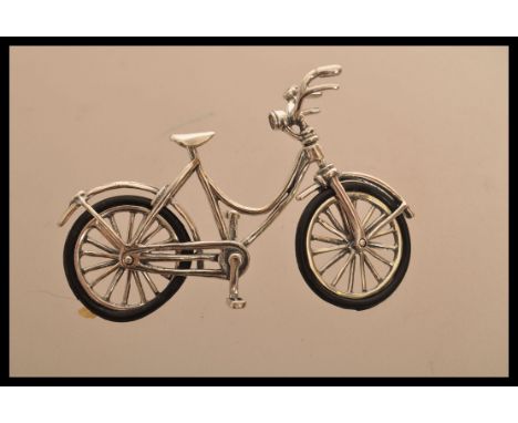 A sterling silver vintage style miniature model of bicycle with rubber tires. Weighs 10.9 grams.