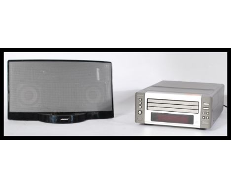 A 20th Century Denon Compact Disc player together with a Bose docking station speaker.