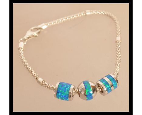 A sterling silver Tiffany style bracelet set with enamel and blue opal. Weighs 12 grams.