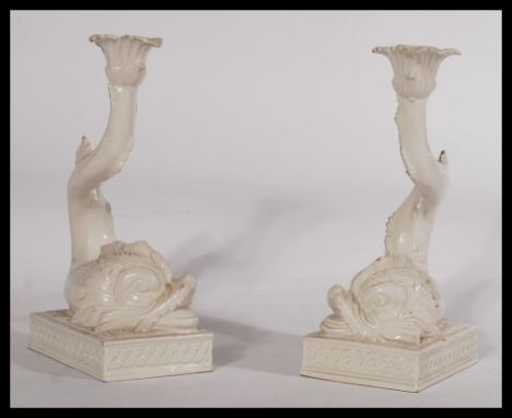 A pair of decorative 20th century Italian ceramic candlesticks in the form of mythical fish. Raised on rectangular plinth bas