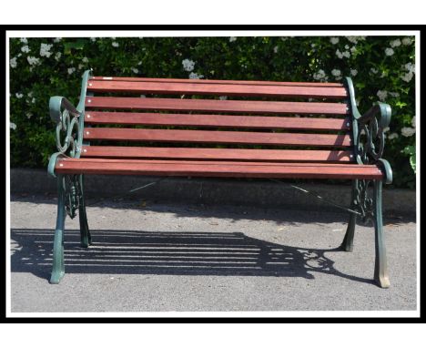 A very heavy 20th century cast metal garden bench, recently having new wooden slats added and a fresh coat of paint.
