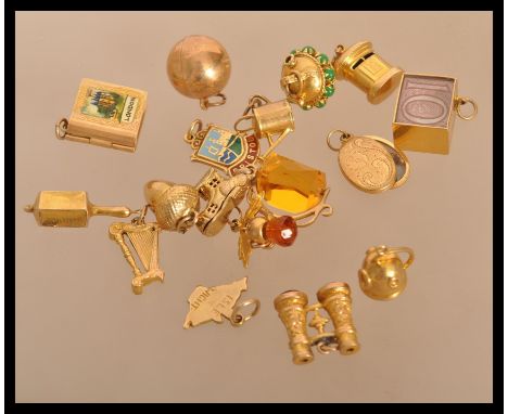 A good group of 9ct gold bracelet charms to include a bowling ball , 10 Shilling note , Boot house , bloodstone agate opera g