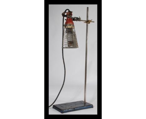 A vintage 20th Century Industrial inspection lamp suspended from an early 20th Century George and Becker cast metal medical s