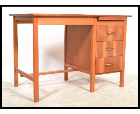 A retro mid century teak wood pedestal desk. Raised on squared legs with open kneehole recess flanked by a pedestal bank of d