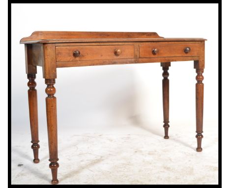 A 19th century Victorian mahogany writing table desk being gallery backed. Raised on turned column legs with two drawer friez