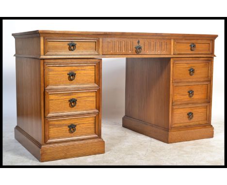 A good large antique style oak twin pedestal writing desk having tooled red leather writing skiver. The pedestals with carved