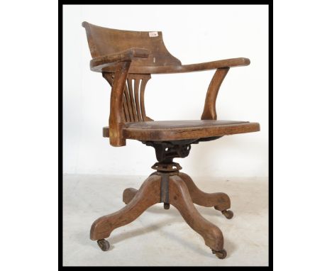 An early 20th century Industrial office swivel chair / desk armchair being raised on quadruped base with pad seat and fan bac