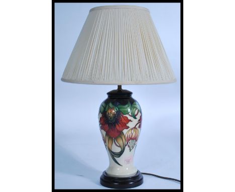Moorcroft pottery table lamp, baluster-shaped with tube-lined decoration of various flowers together with a hand made silk sh