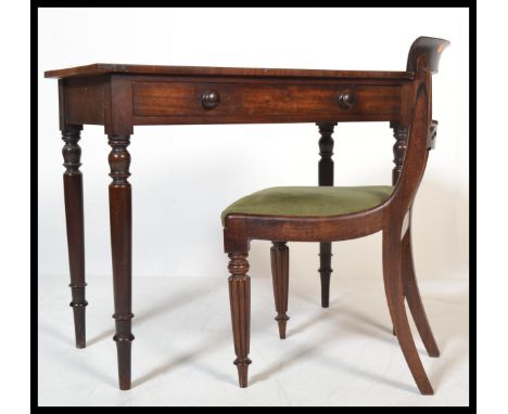 A Victorian mahogany writing table desk raised on turned and tapering legs with fitted frieze drawers and flared top above. T