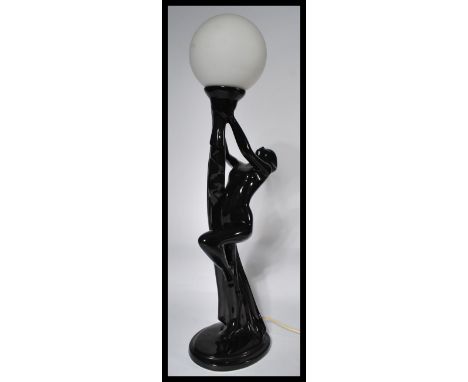 A 20th Century ceramic table lamp finished with a black glaze modelled as an Art Deco lady from the early 20th Century fitted