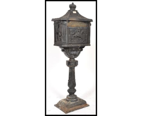 A reproduction Victorian style painted cast metal floorstanding letter box with simulated tiled roof, crown finial and horse 