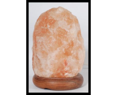 A retro Himalayan original 1970's salt crystal lamp in orange form being raised on an circular plinth base. Measures 22 cm hi