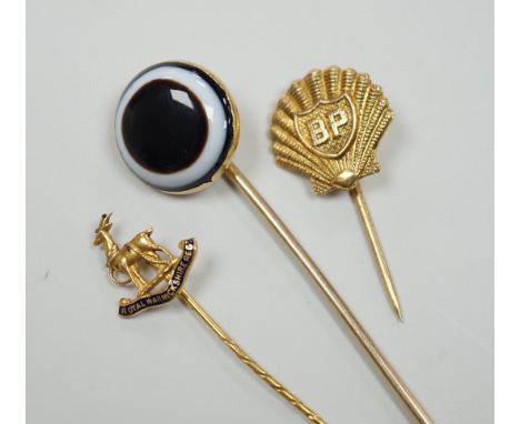 A Victorian yellow metal and banded agate set stick pin, 84mm, a yellow metal Royal Warwickshire Regt. stick pin and a 1970's