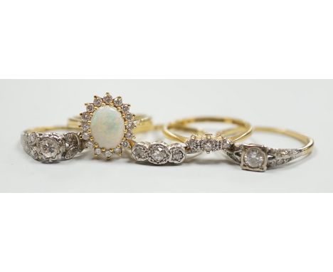 Four assorted 18ct and gem set dress rings, including white opal and diamond and two three stone diamond and one yellow metal