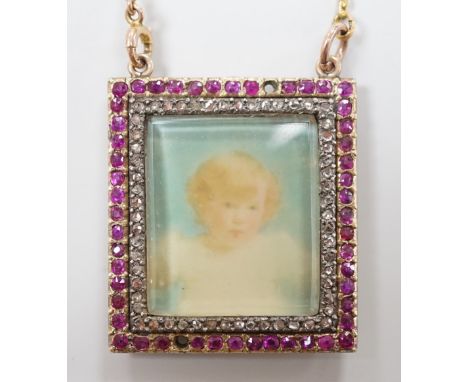 An early 20th century yellow metal, ruby and diamond mounted portrait pendant, 34mm (two rubies missing), on a 9ct chain, gro