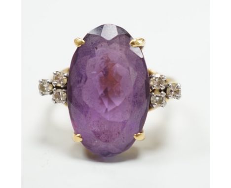 A yellow metal and oval cut amethyst set dress ring, with six stone diamond set shoulders, size O, gross weight 9.6 grams.