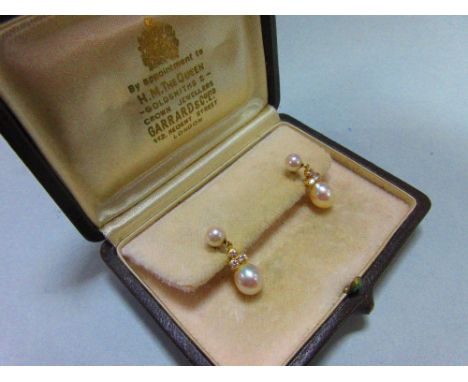A pair of pearl and diamond earpendants cased by Garrard, each post headed by a 5mm pearl and suspending a trio of round bril